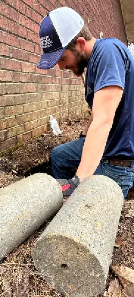 Installing piers in Knoxville foundation repair job.